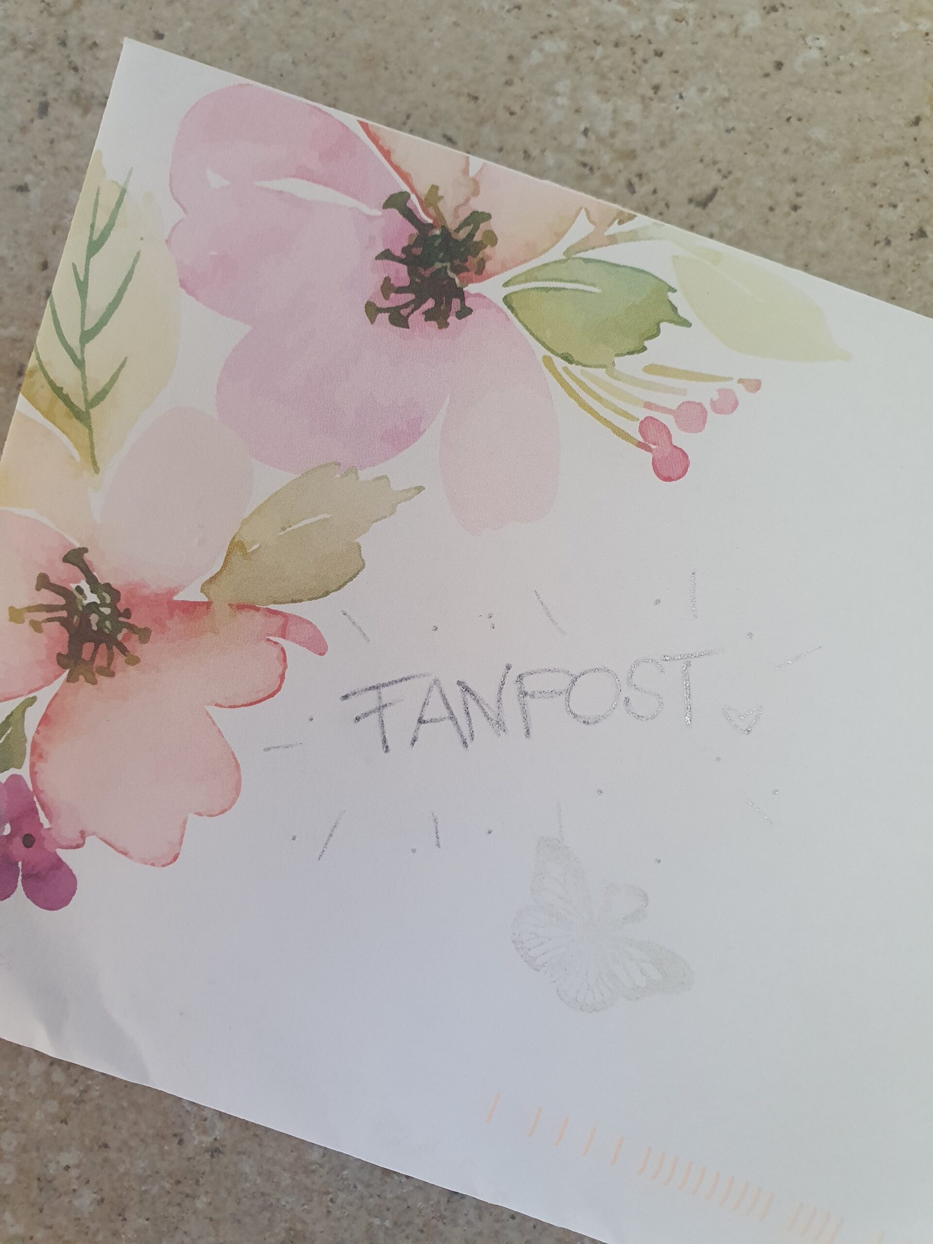 Briefumschlag mit farbigen Blumen in der Ecke und einem gezeichneten Schmetterling. Text: Fanpost